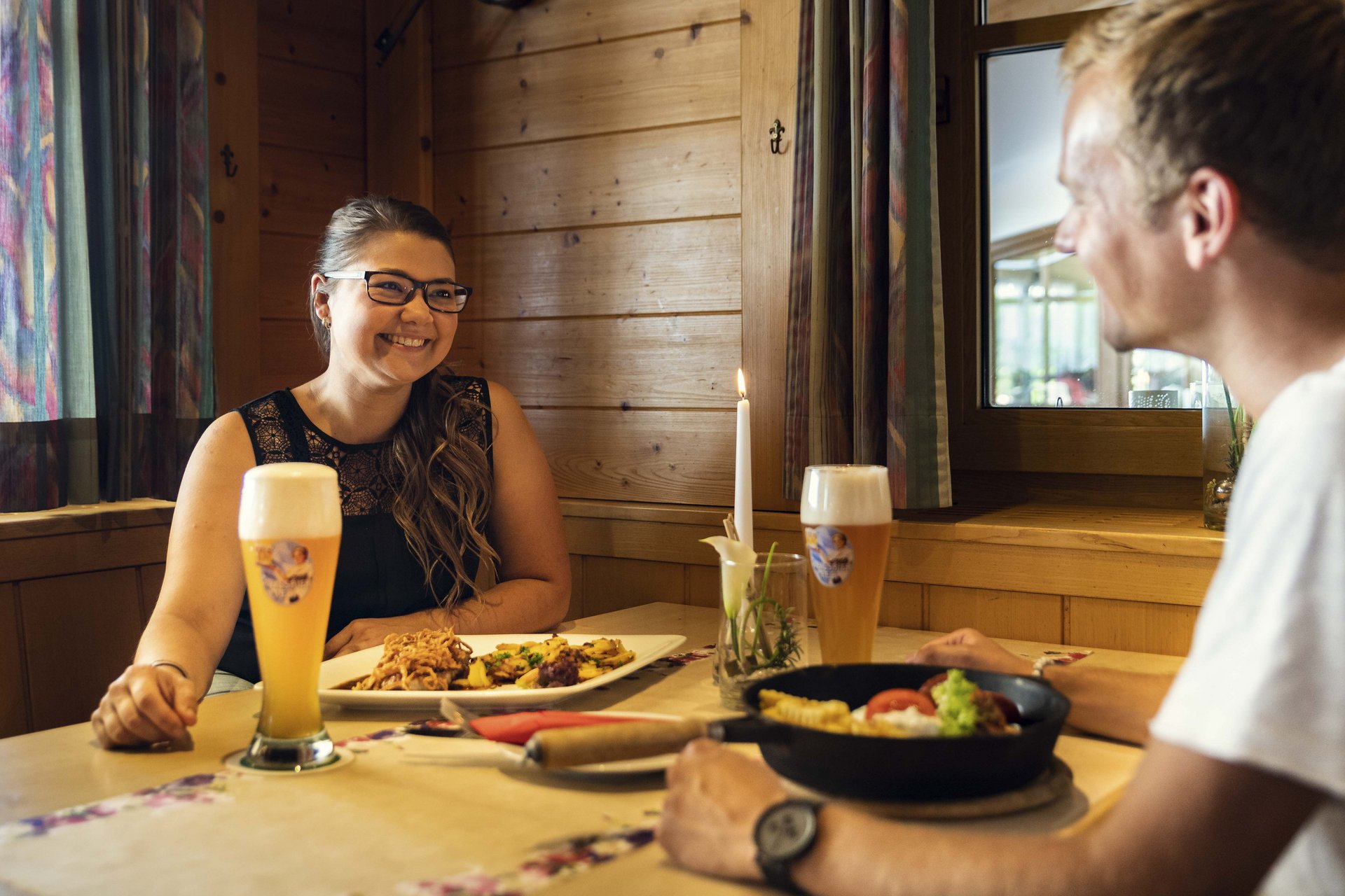 Bild: Ein Mann und eine Frau, die zusammen Essen und Bier trinken.