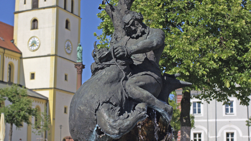 Bild: Die Mitterteicher Skulptur am Marktplatz. Im Hintergrund ist die Kirche zu sehen.